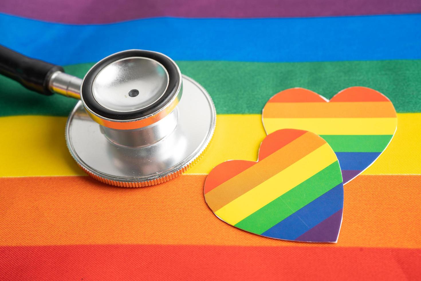 Black stethoscope with heart on rainbow flag background, symbol of LGBT pride month  celebrate annual in June social, symbol of gay, lesbian, bisexual, transgender, human rights and peace. photo