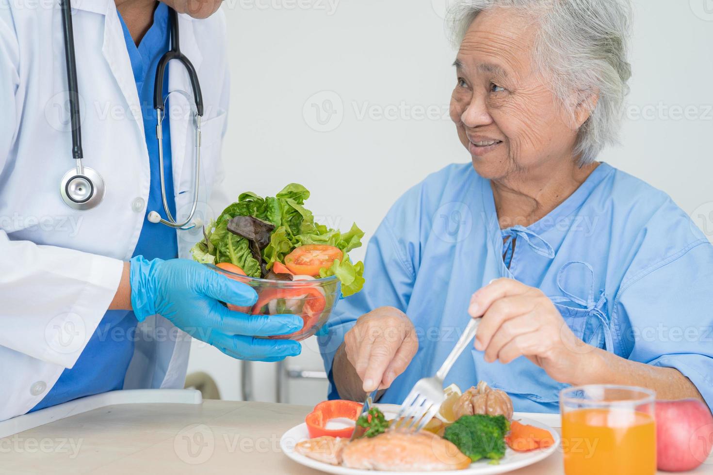 Paciente asiático mayor o anciano mujer desayunando vegetales alimentos saludables con esperanza y feliz mientras está sentado y hambriento en la cama en el hospital. foto