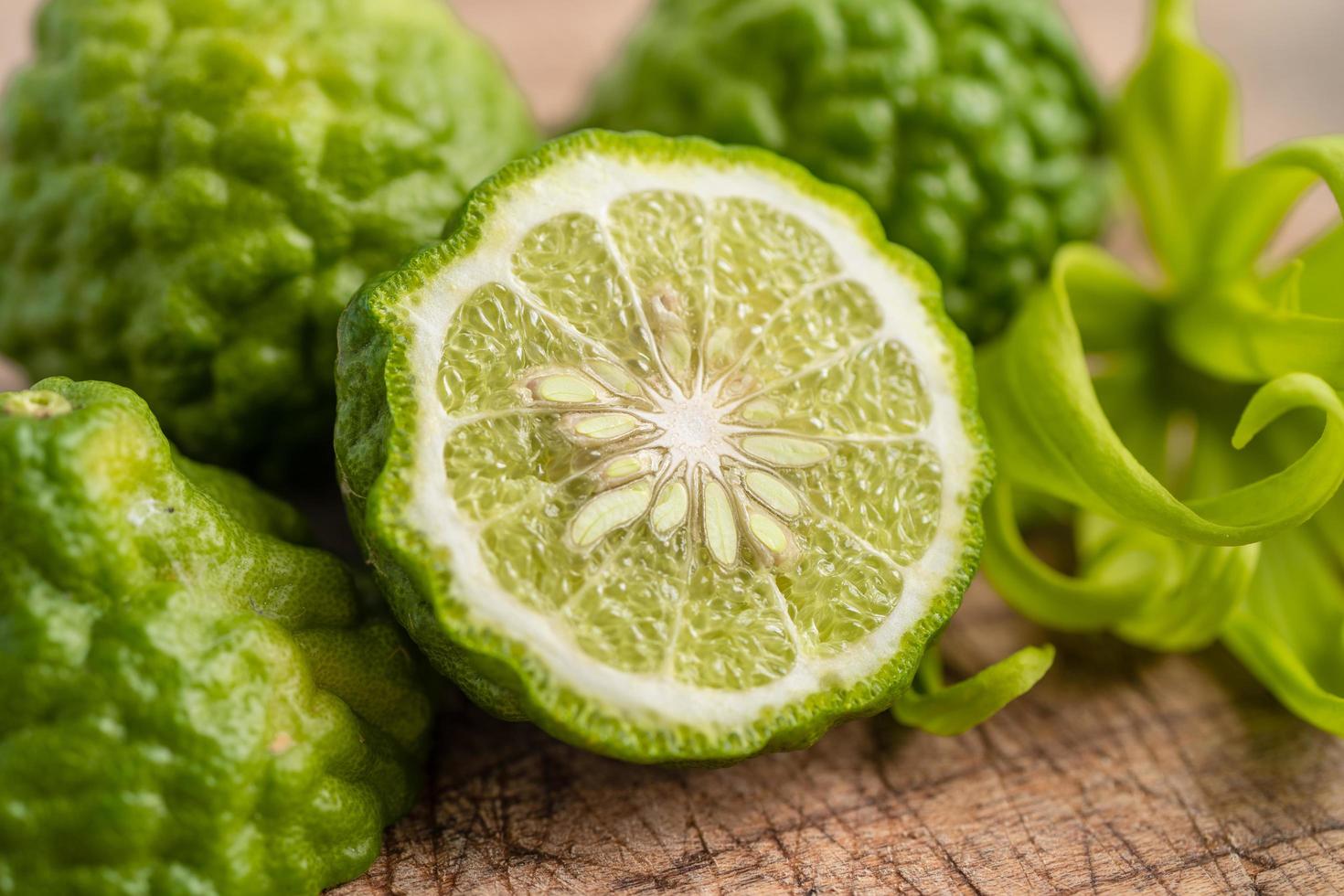 Fruta de bergamota fresca cortada por la mitad sobre fondo de madera. foto