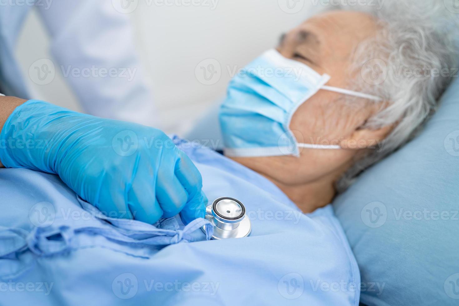 Doctor help Asian senior or elderly old lady woman patient wearing a face mask in hospital for protect safety infection and kill Covid-19 Coronavirus. photo