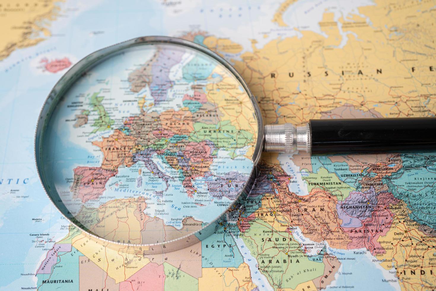 Bangkok, Thailand - August 01, 2020 Europe, Magnifying glass close up with colorful world map photo