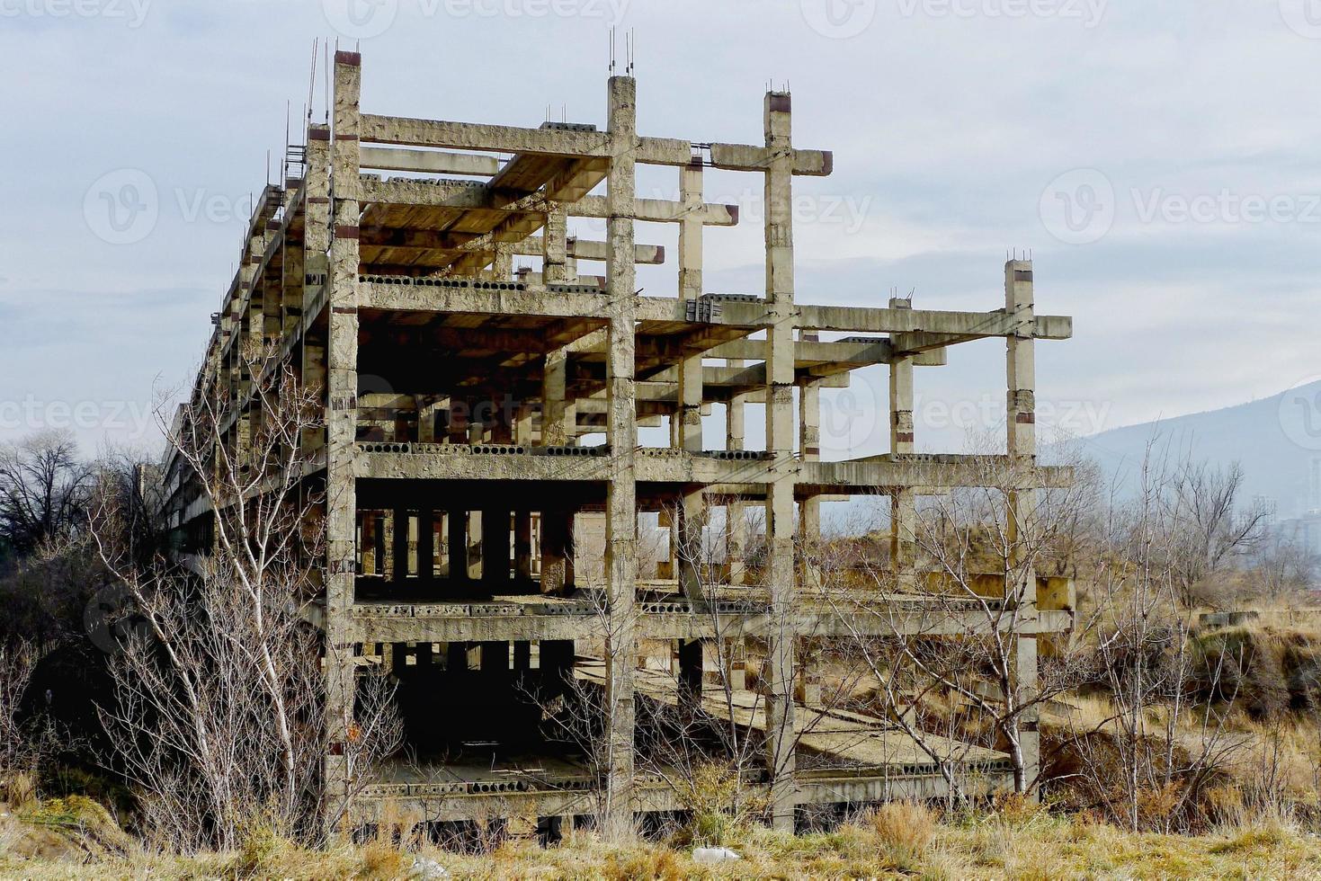 Unfinished and abandoned concrete building carcass. Abandoned building construction. photo