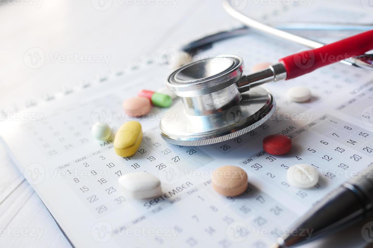top view of pills and stethoscope on calendar , photo