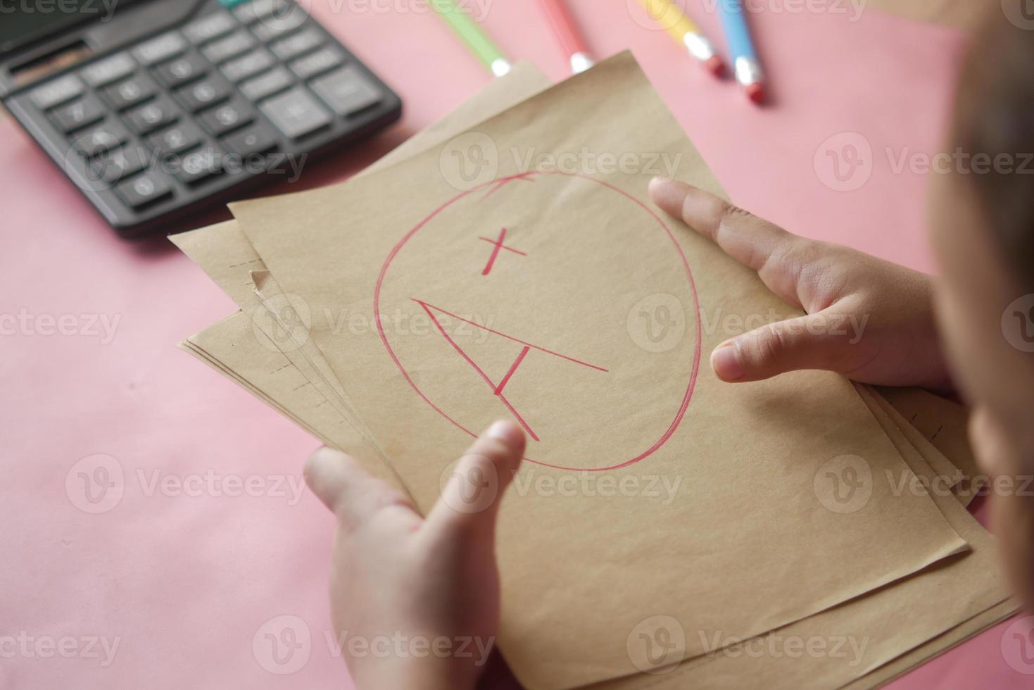 hand holding paper with Hand drawn grade with plus in circle photo