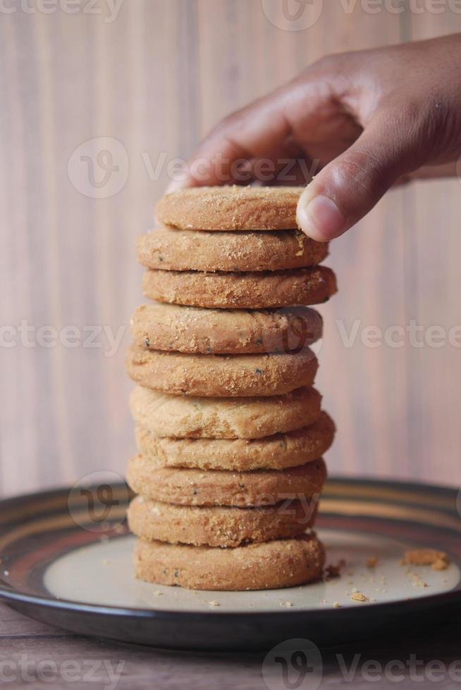 hand pick sweet cookies on wooden table photo