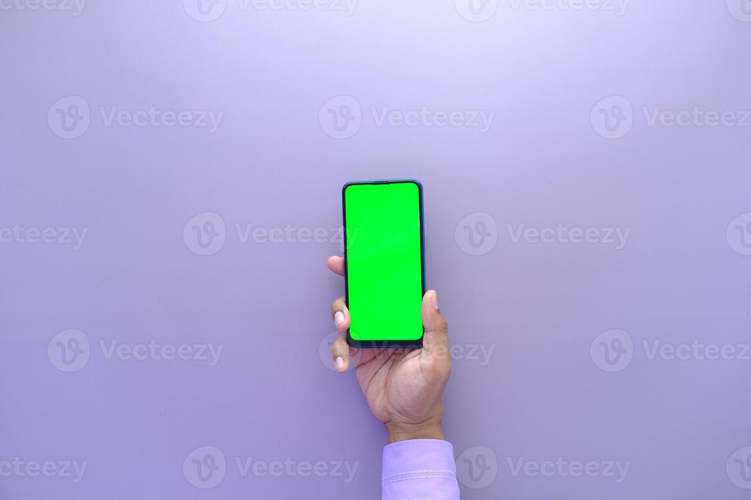 top view of young man hand using smart phone with green screen photo