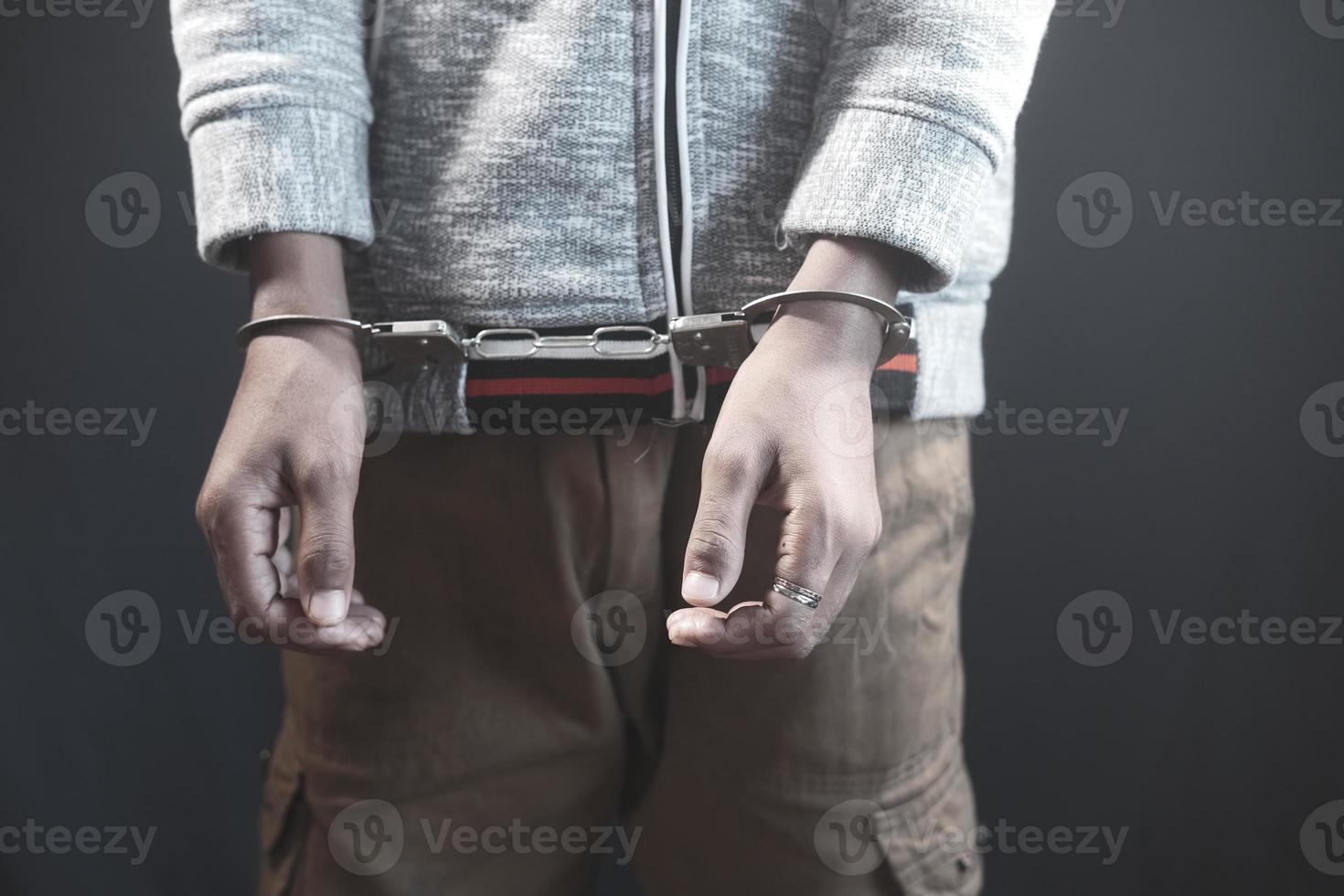 man's hand with handcuff on black background. photo