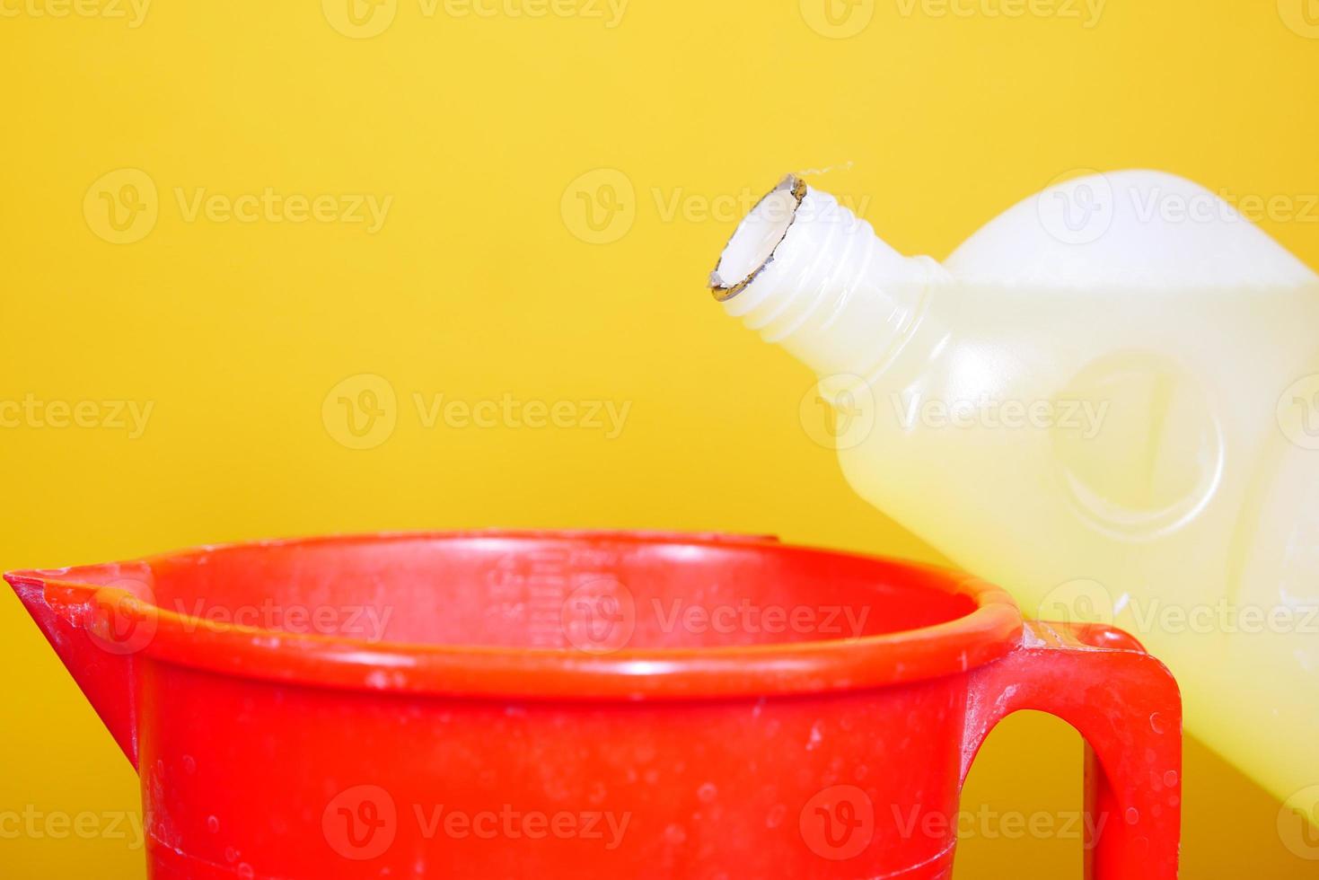 Botella de desinfección de limpieza de suelos contra el fondo amarillo foto