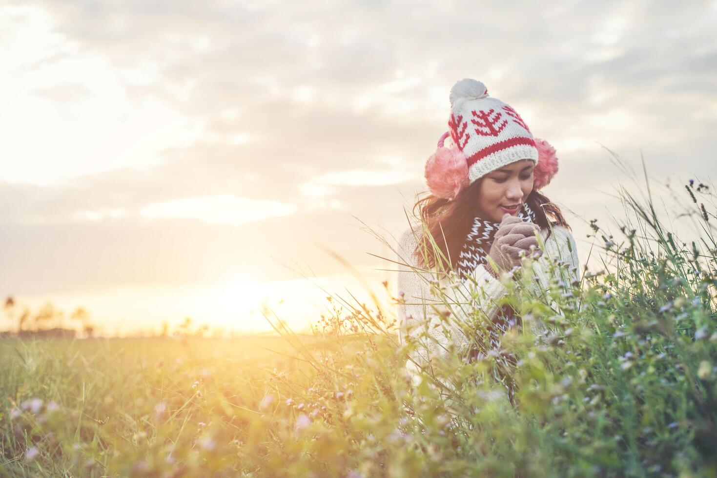 joven mujer hermosa con ropa de invierno mientras está de pie disfruta con la naturaleza. concepto de horario de invierno. foto