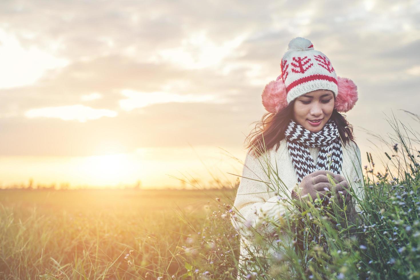 joven mujer hermosa con ropa de invierno mientras está de pie disfruta con la naturaleza. concepto de horario de invierno. foto