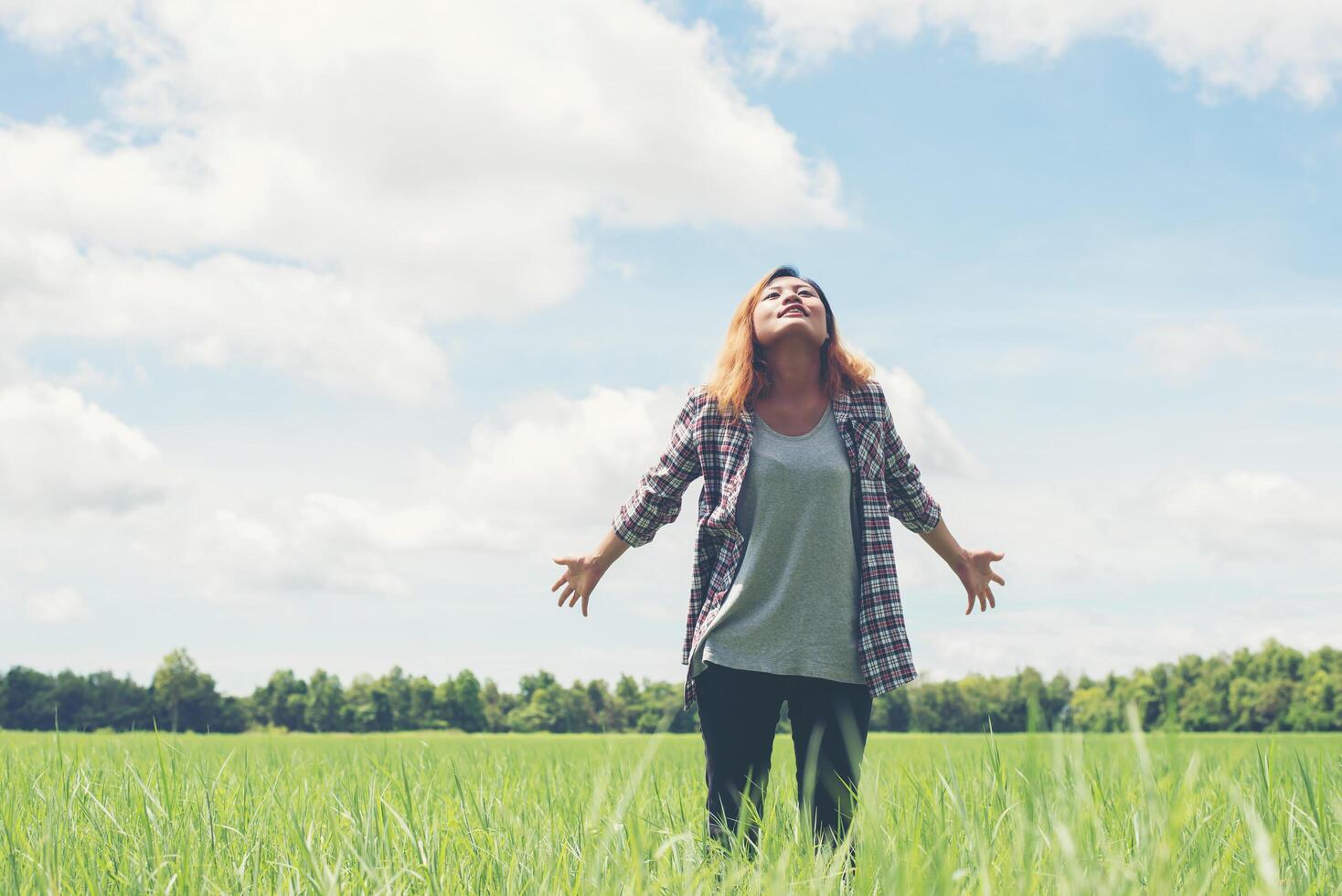 Freedom Young beautiful woman stretching her arms into the sky enjoy and happy with fresh air at grassland. photo