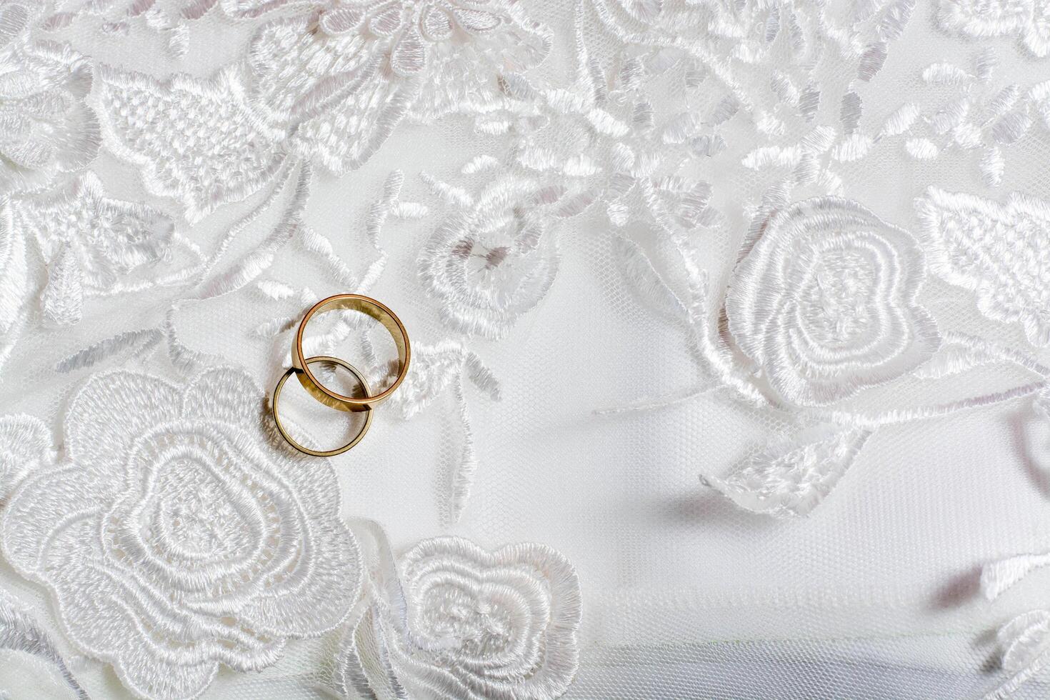 dos anillos de boda sobre el vestido de novia foto