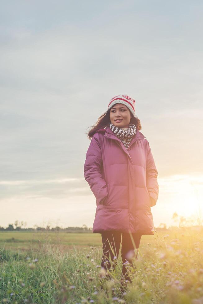 mujer joven estaba jugando en un campo de flores en el aire de invierno. foto