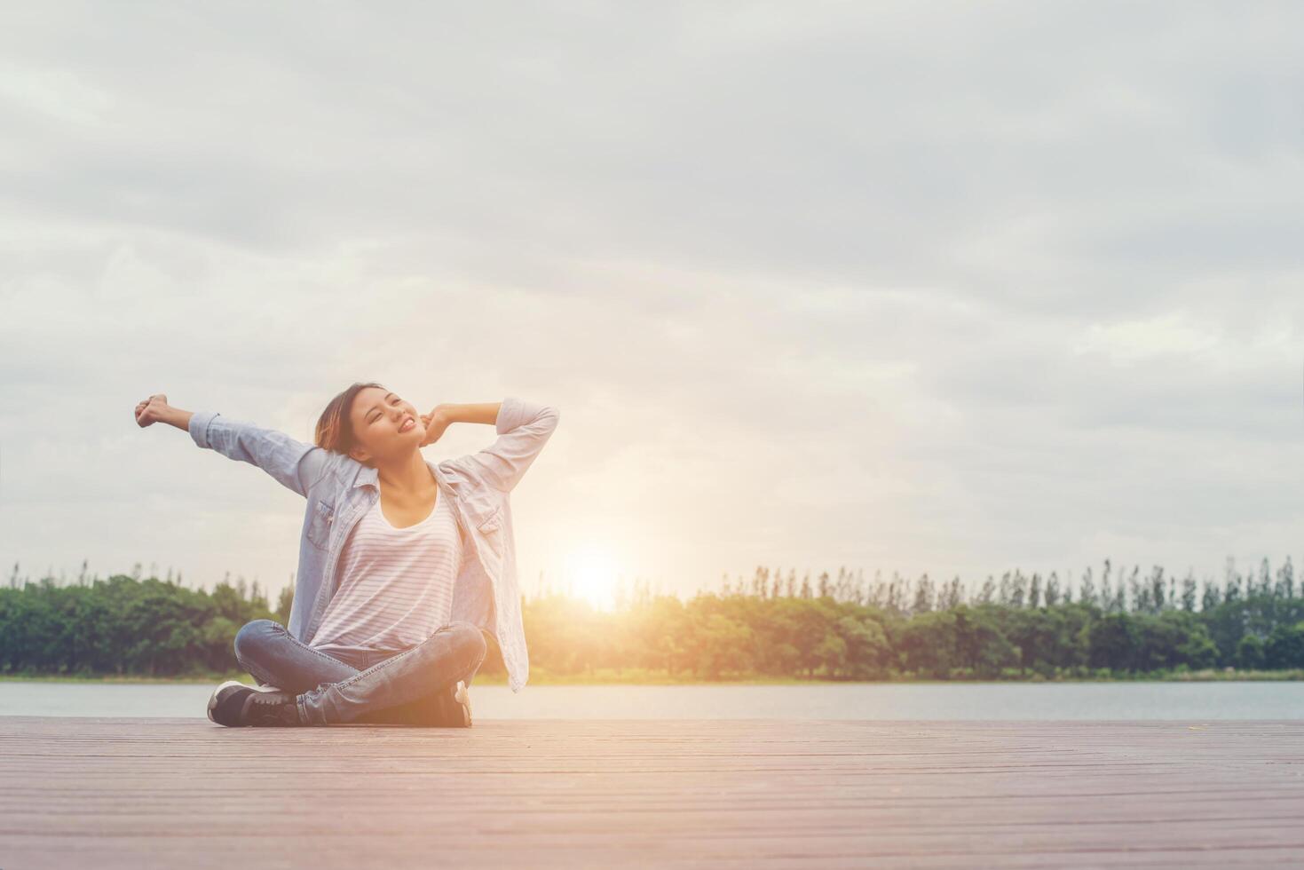 young beautiful hipster woman sitting on lake holiday relaxing enjoy with nature. photo