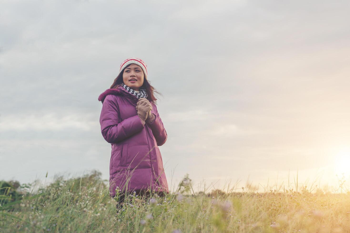 Young woman was playing in a field of flowers in the winter air. photo