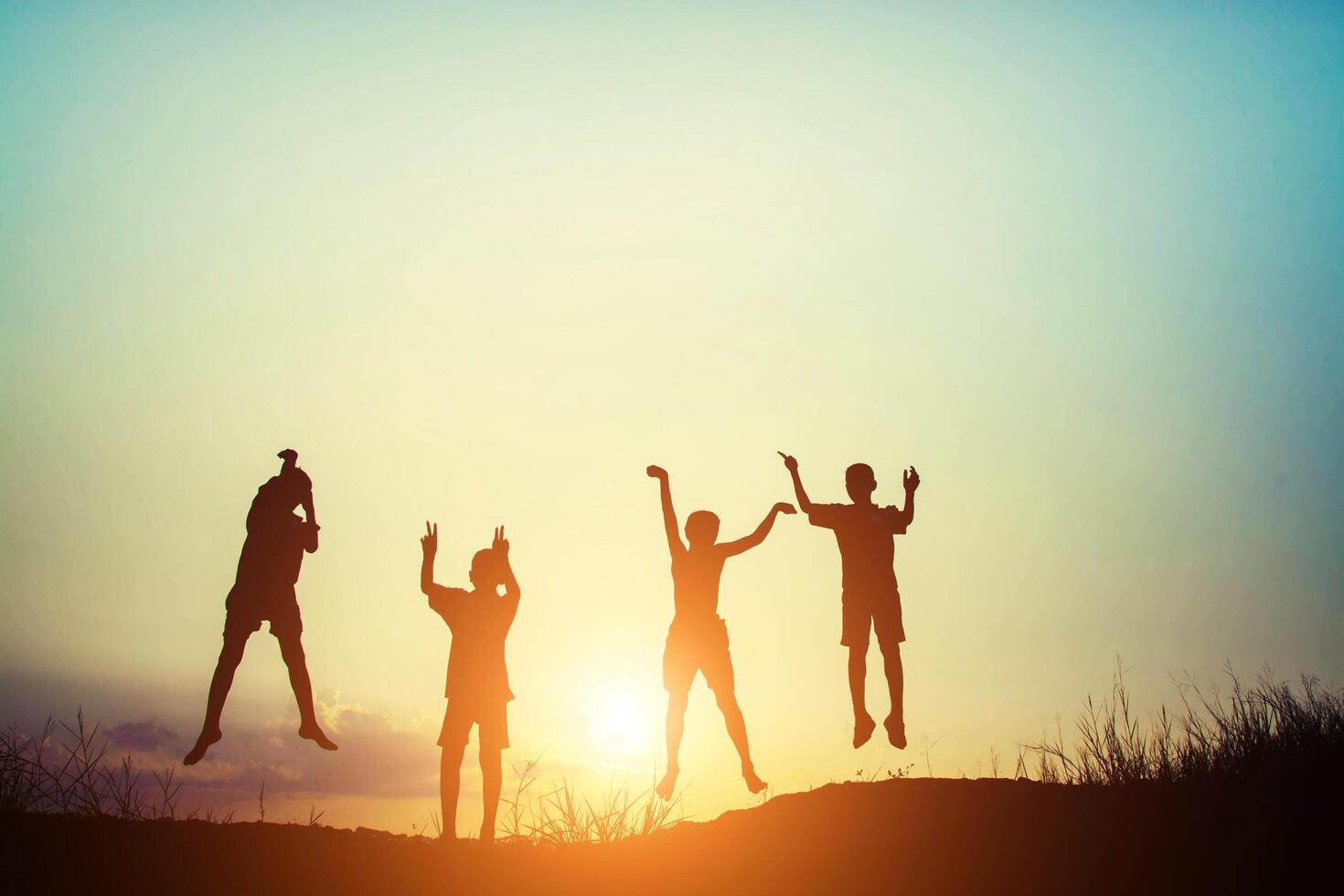 silueta de niños salto alegría tiempo feliz foto