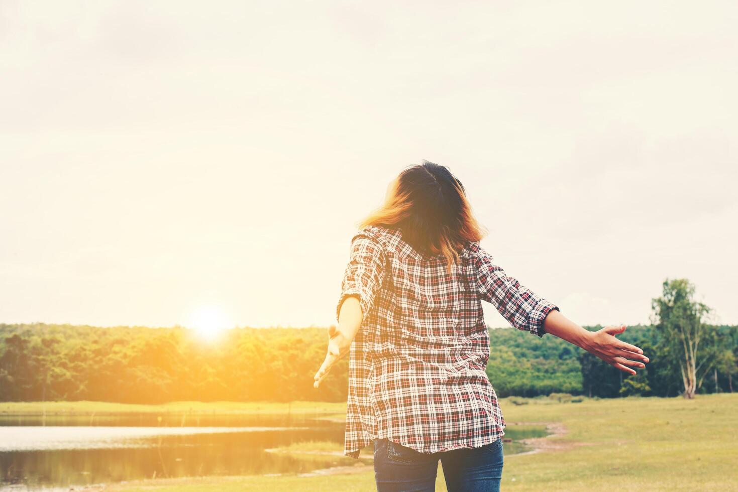 Woman lifestyle concept  young beautiful woman stretching hands in the air enjoy with fresh air outside nature. photo