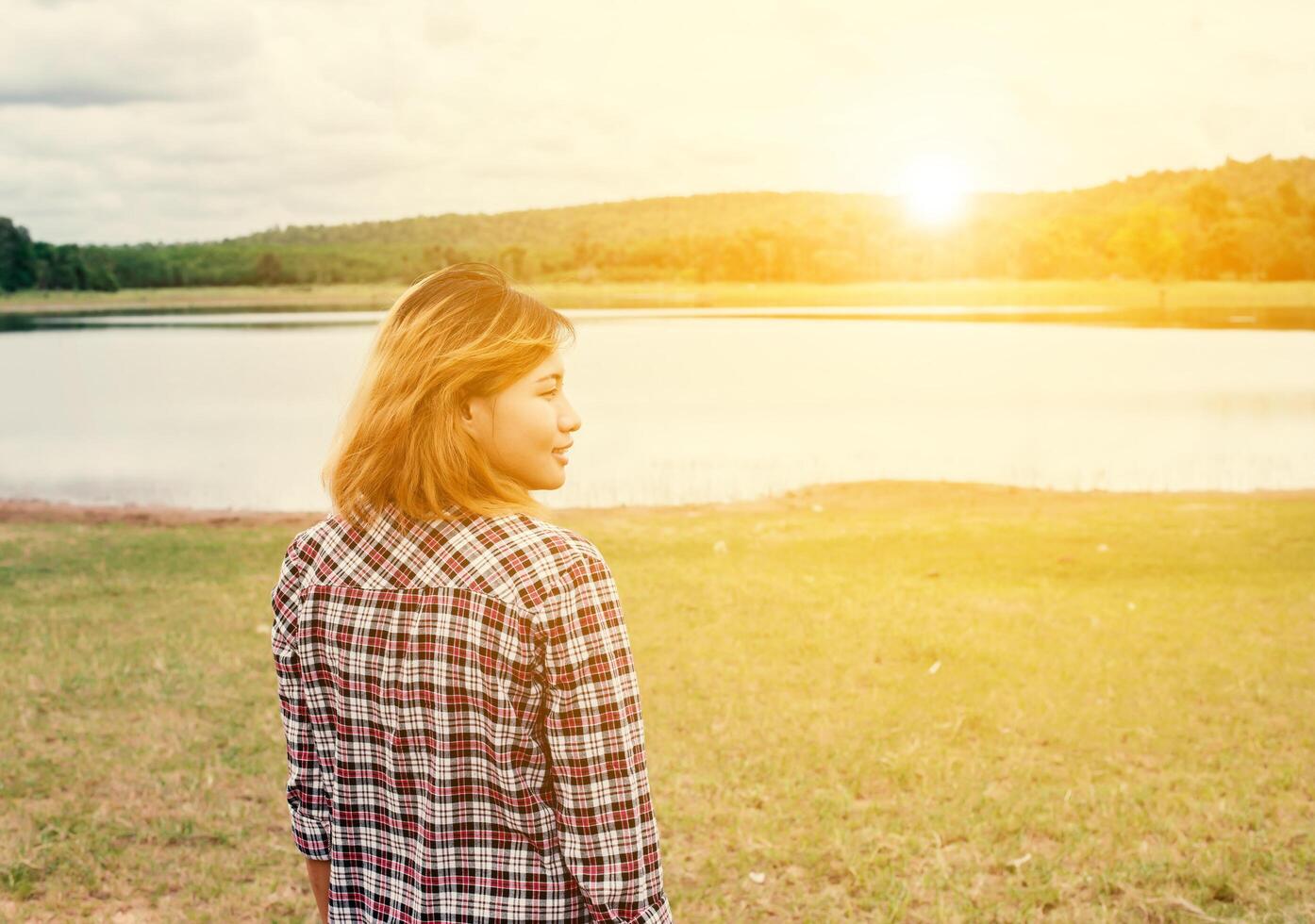 Young hipster woman walk to the lake enjoy nature and fresh air. photo