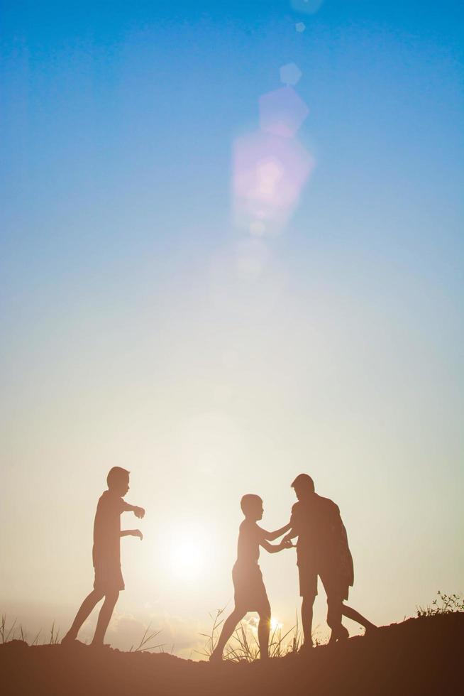 Silhouette of children playing in the park sunset time photo