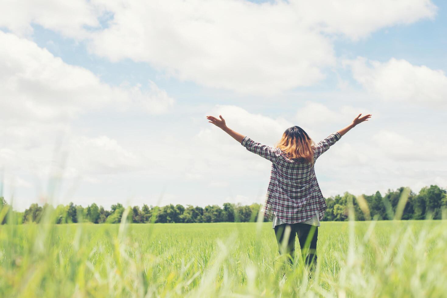 Freedom Young beautiful woman stretching her arms into the sky enjoy and happy with fresh air at grassland. photo