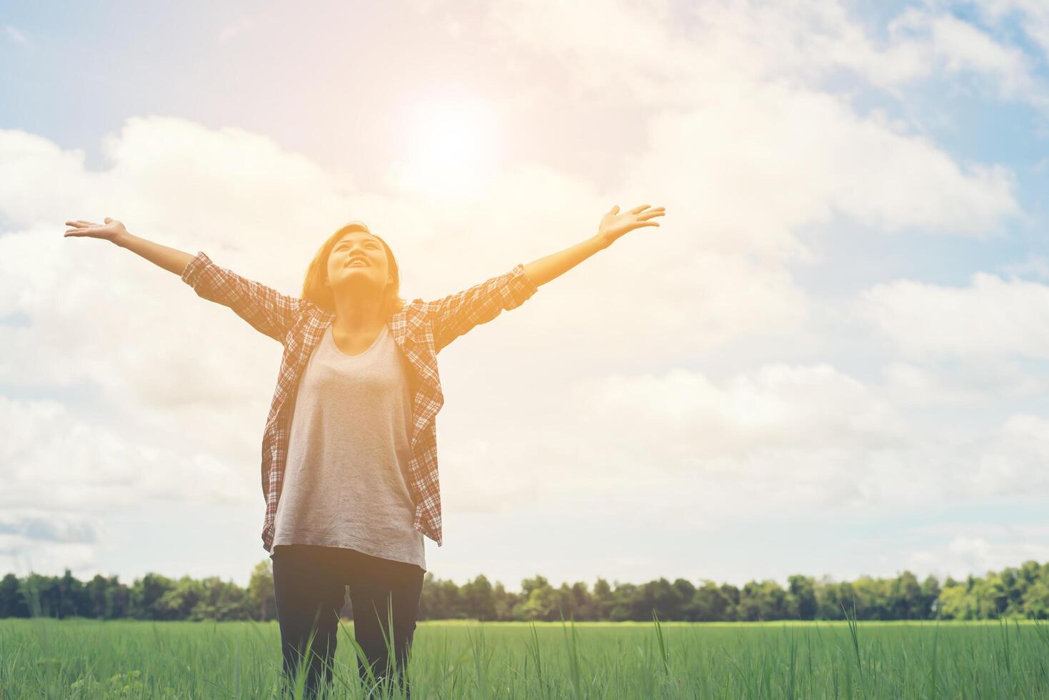 Freedom Young beautiful woman stretching her arms into the sky enjoy and happy with fresh air at grassland. photo