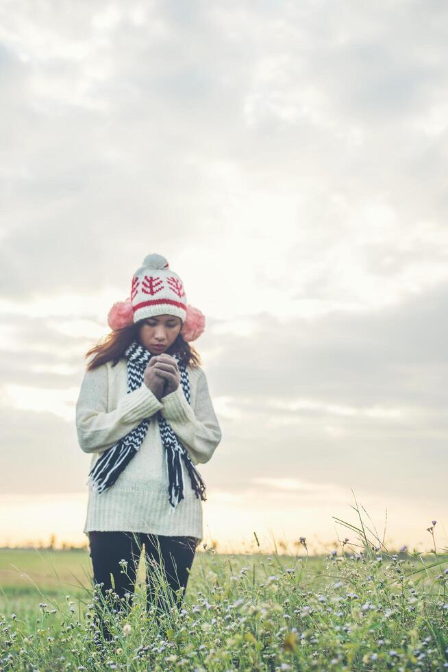 Young beautiful woman wearing winter clothing while standing enjoy with nature. Winter time concept. photo