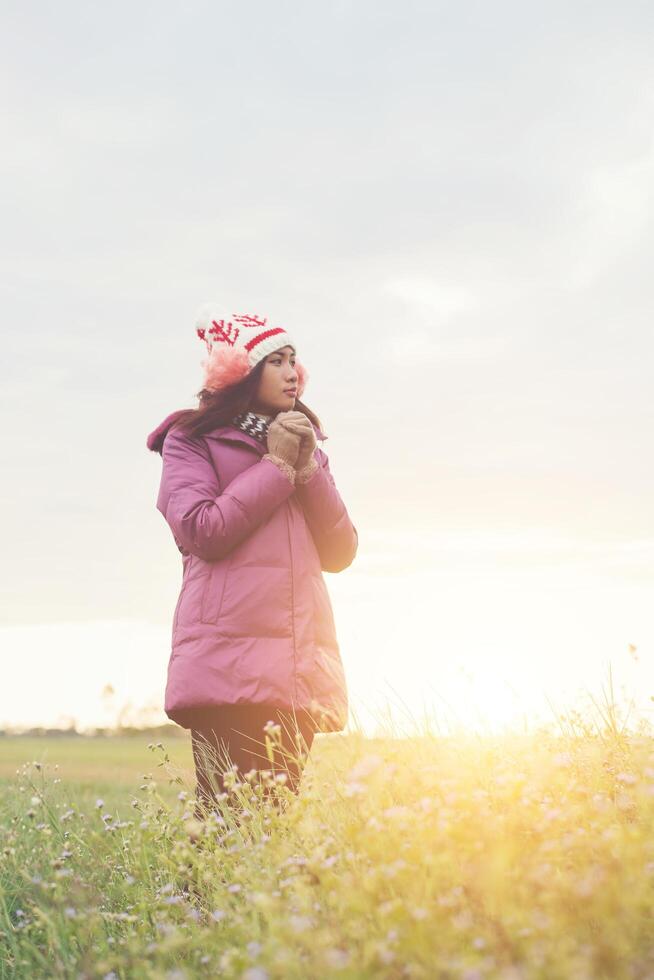 Young woman was playing in a field of flowers in the winter air. photo