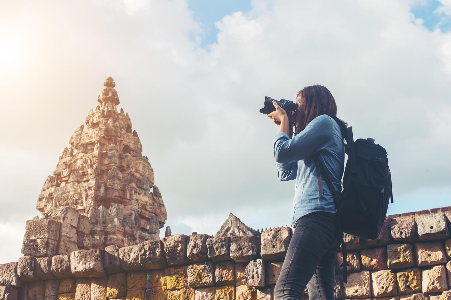 joven y atractiva mujer fotógrafa turista con mochila que viene a tomar fotos en el antiguo templo de peldaño fantasma en tailandia.