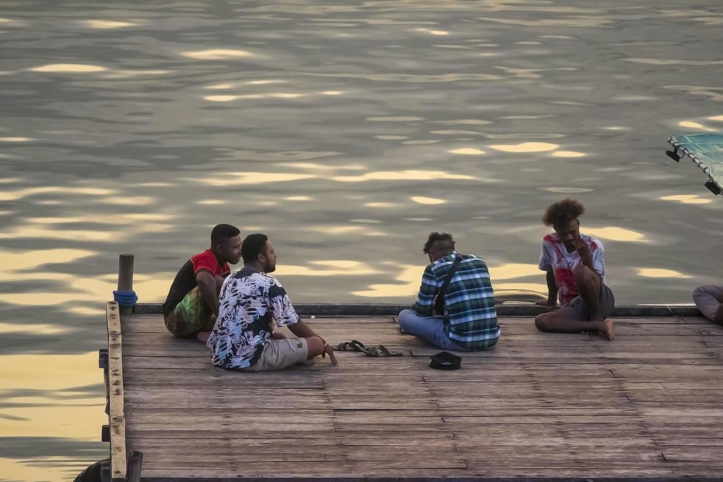 sorong, papúa occidental, indonesia, 30 de septiembre de 2021. gente pasando el rato en el embarcadero de madera foto