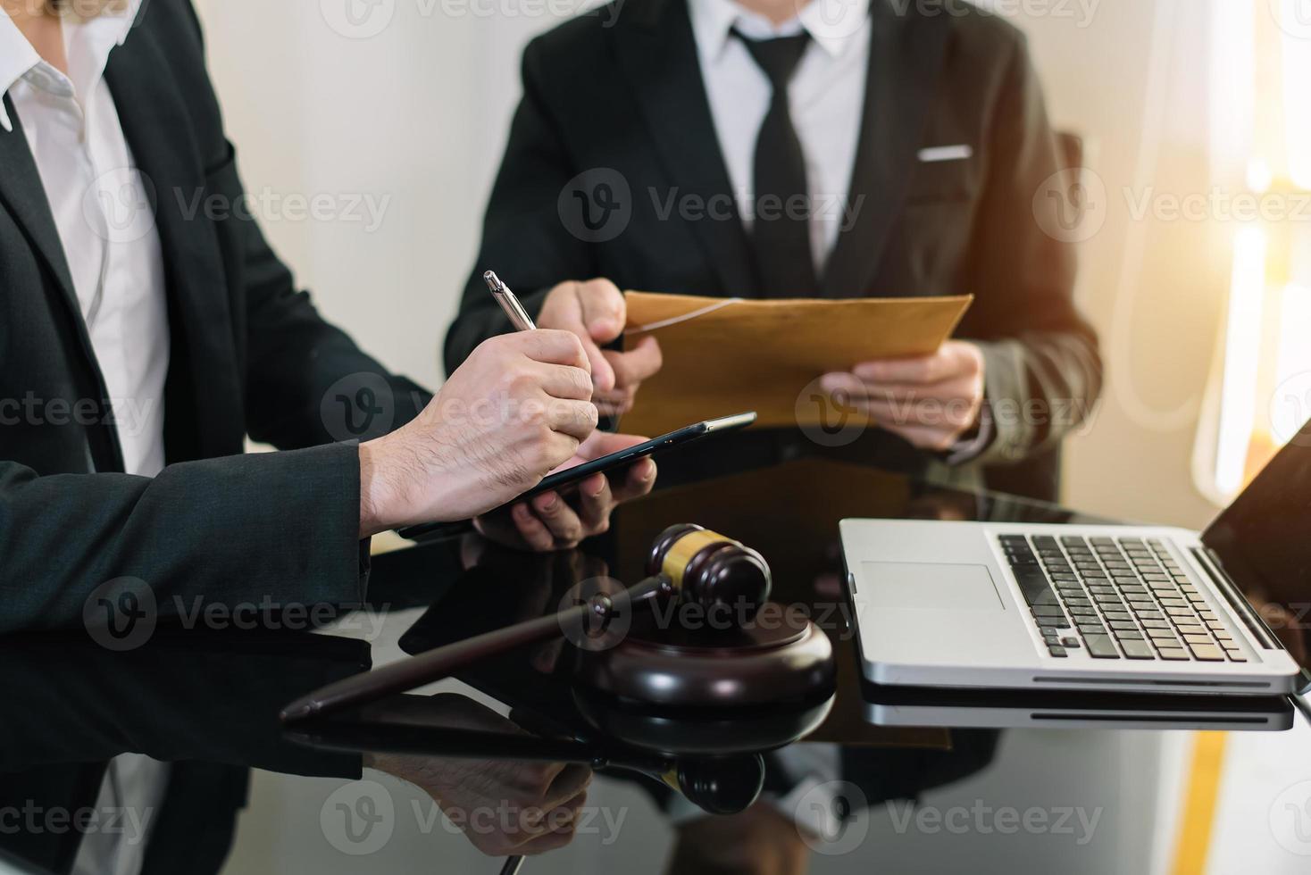 negocios y abogados discutiendo documentos contractuales con escala de latón en el escritorio. derecho, servicios legales, asesoramiento, justicia y concepto de derecho. foto