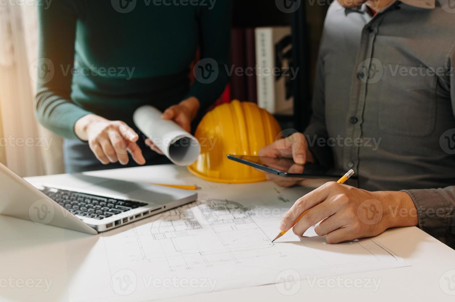 Two colleagues discussing data working and tablet, laptop with on on architectural project at construction site photo