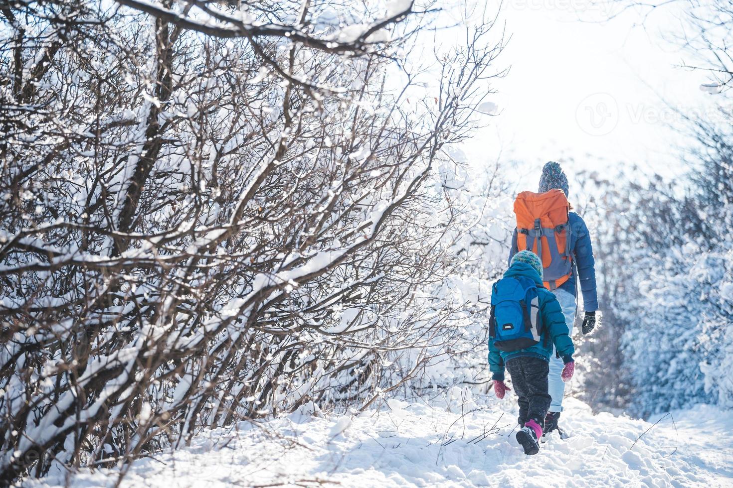 mujer con un niño en una caminata de invierno en las montañas. foto