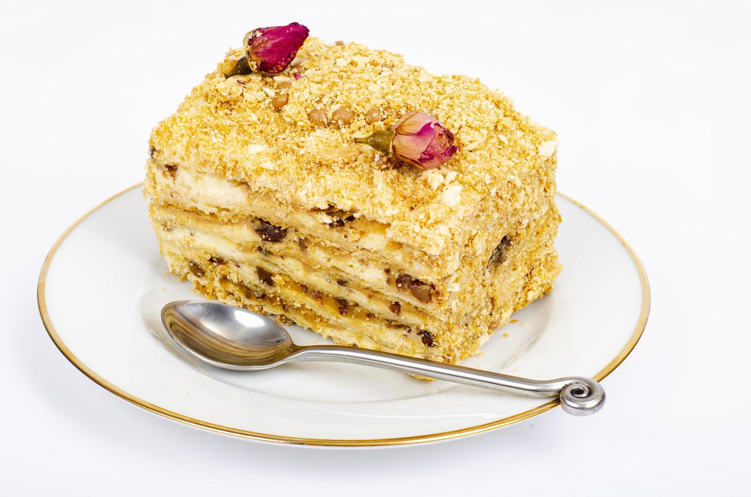 Piece of homemade puff pastry cake with cream on white plate. Studio Photo