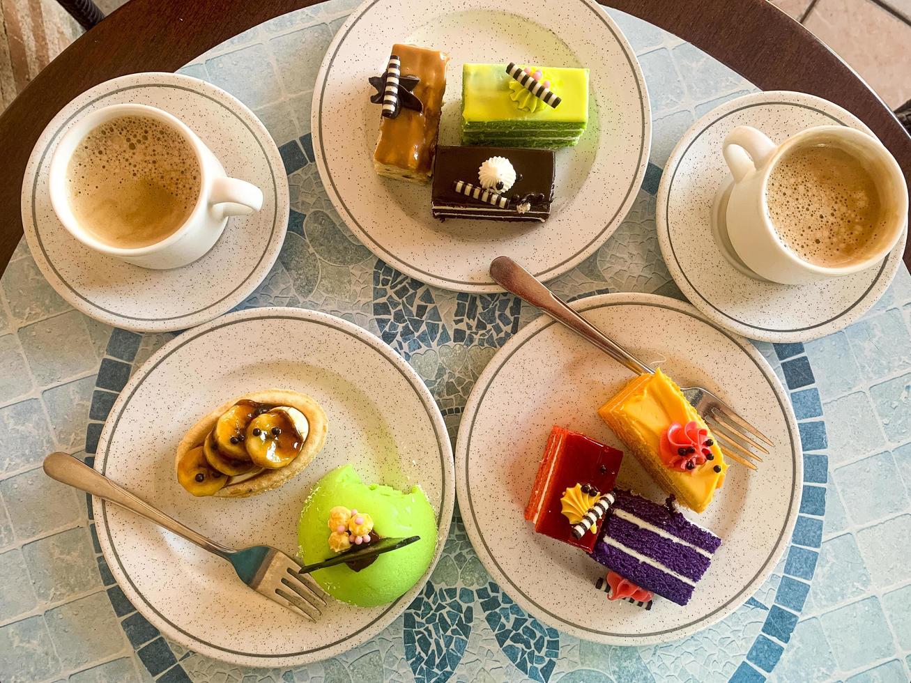 Various colored cakes on plates. Sweet desserts. Studio Photo