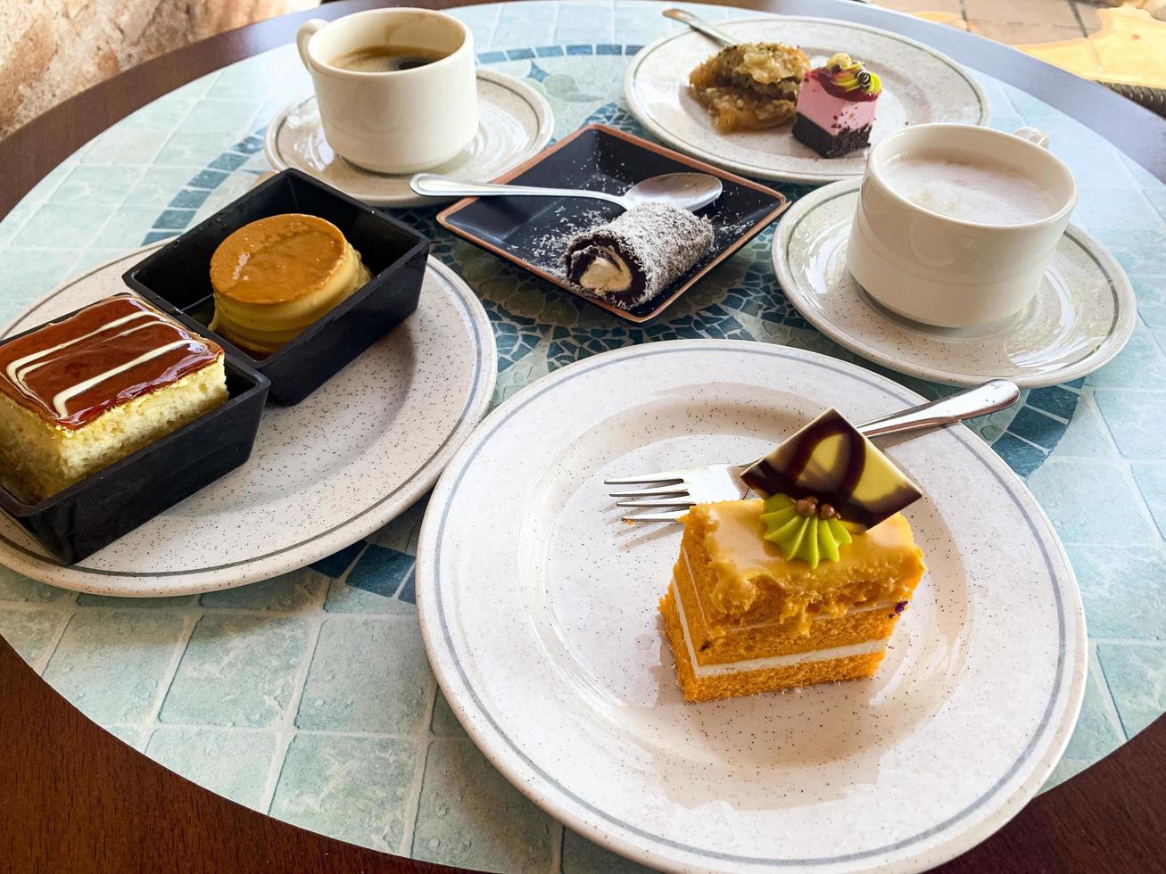 Various colored cakes on plates. Sweet desserts. Studio Photo