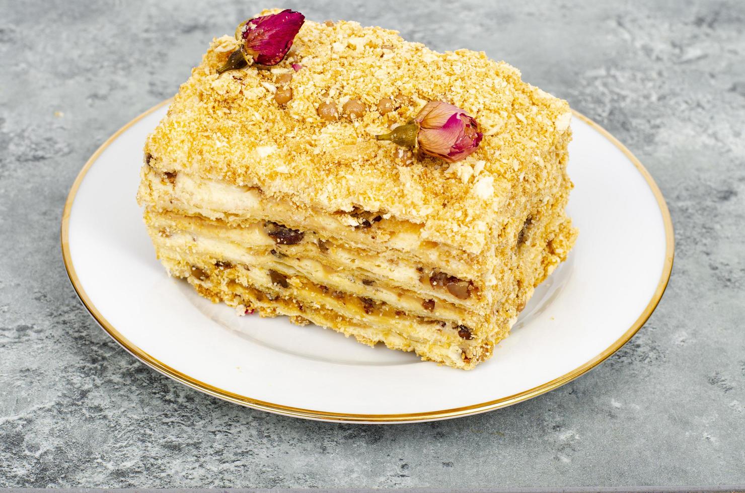 Piece of homemade puff pastry cake with cream on white plate. Studio Photo