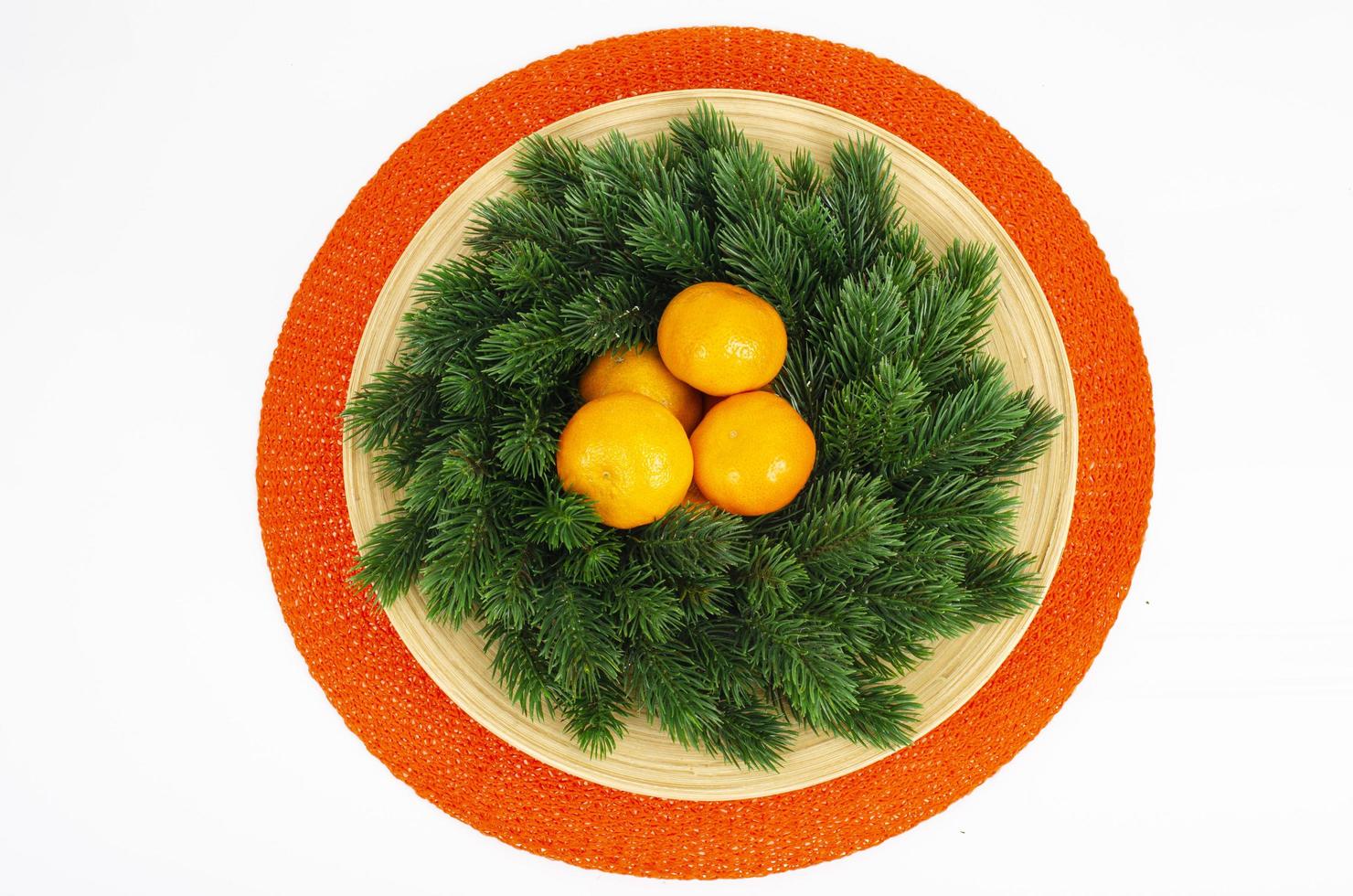 Christmas wreath with tangerines and plate. Studio Photo