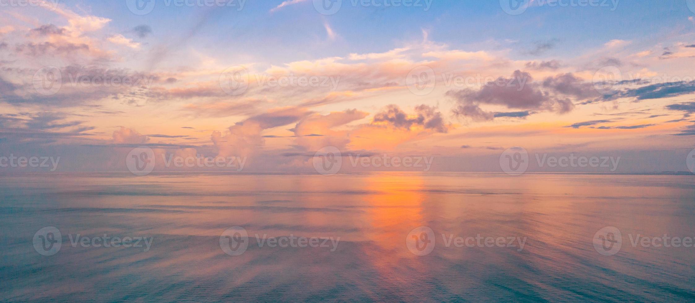 Aerial panoramic view of sunset over ocean. Colorful sky, clouds and water. Beautiful serene scene, relaxing ocean horizon photo