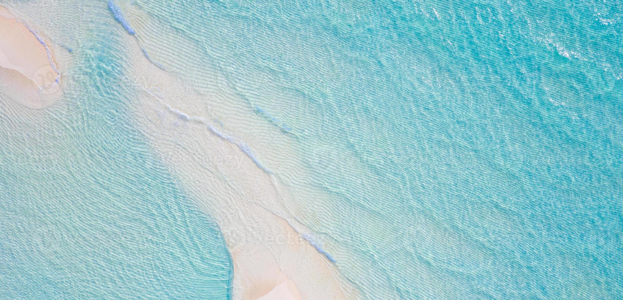 Summer seascape beautiful waves, blue sea water in sunny day. Top view from drone. Sea aerial view, amazing tropical nature background. Beautiful bright sea with waves splashing and beach sand concept photo