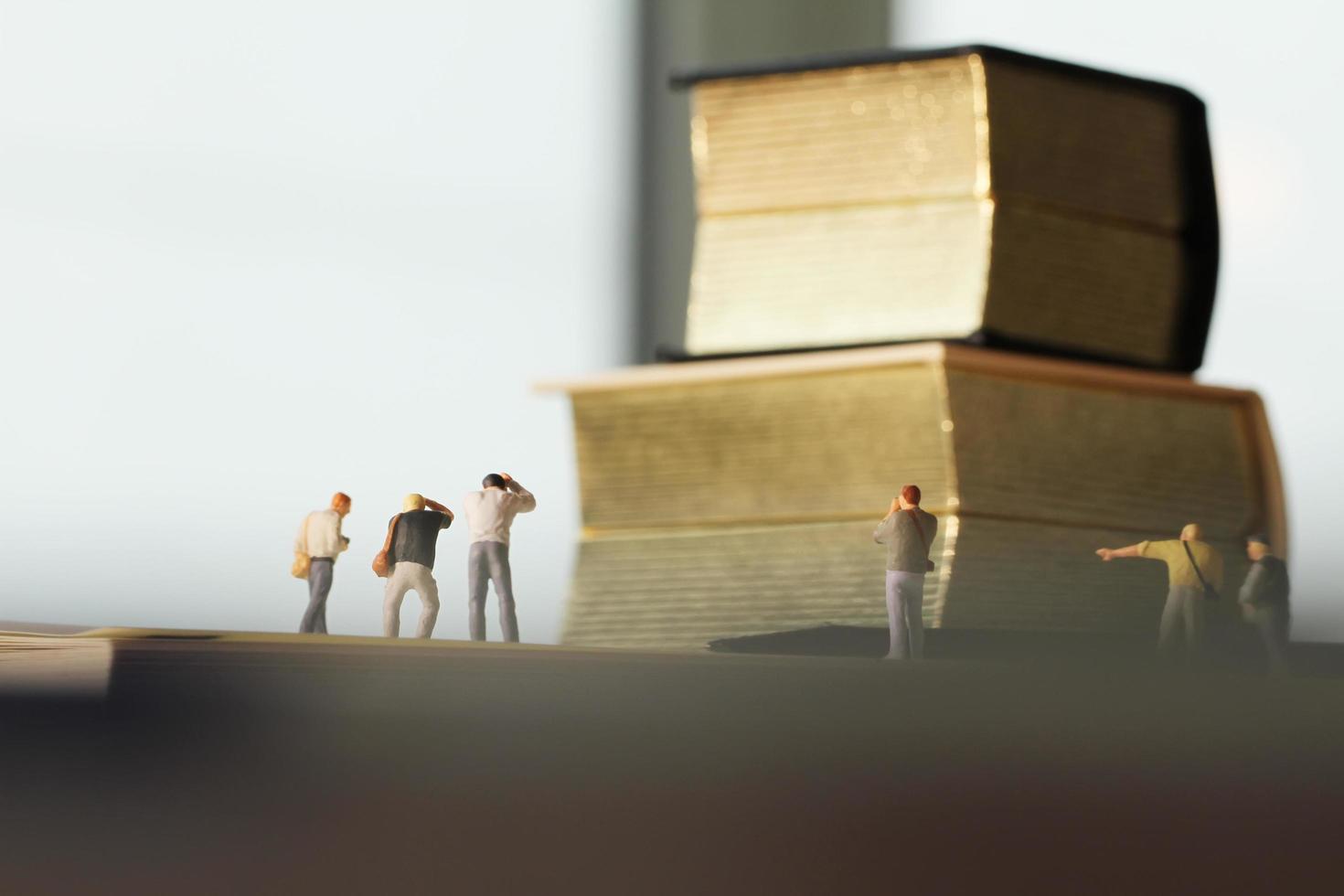 Creative idea concept - miniature photographer with vintage golden book on open paper notebook photo