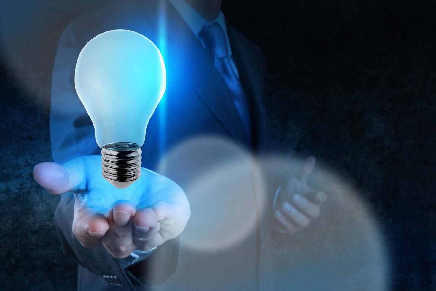 Businessman hand working with 3d light bulb of leadership concept photo