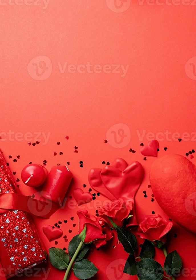 Valentines Day gifts, roses and candles on red backdrop, copy space photo