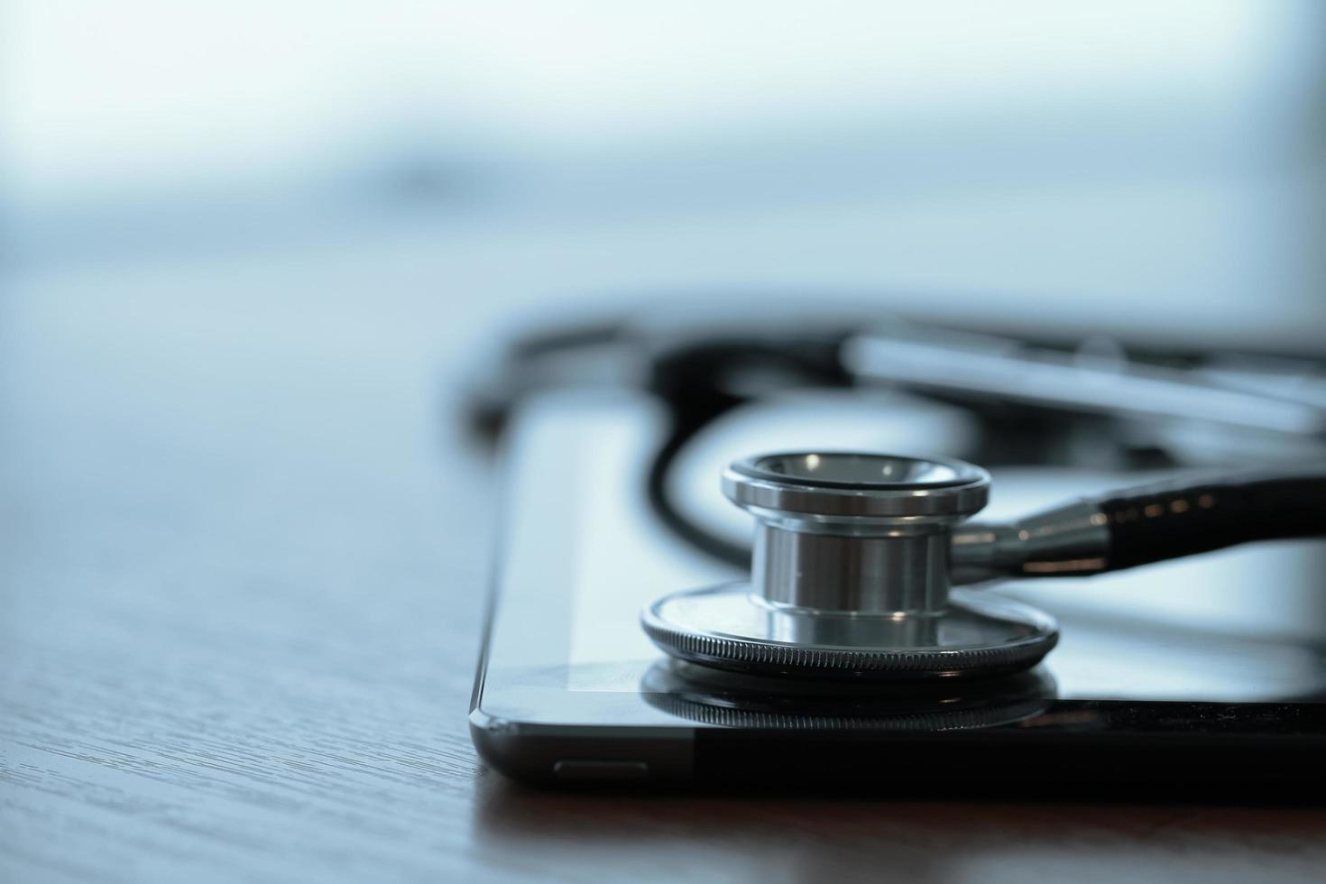 Studio macro of a stethoscope and digital tablet with shallow DOF evenly matched abstract on wood table background copy space photo