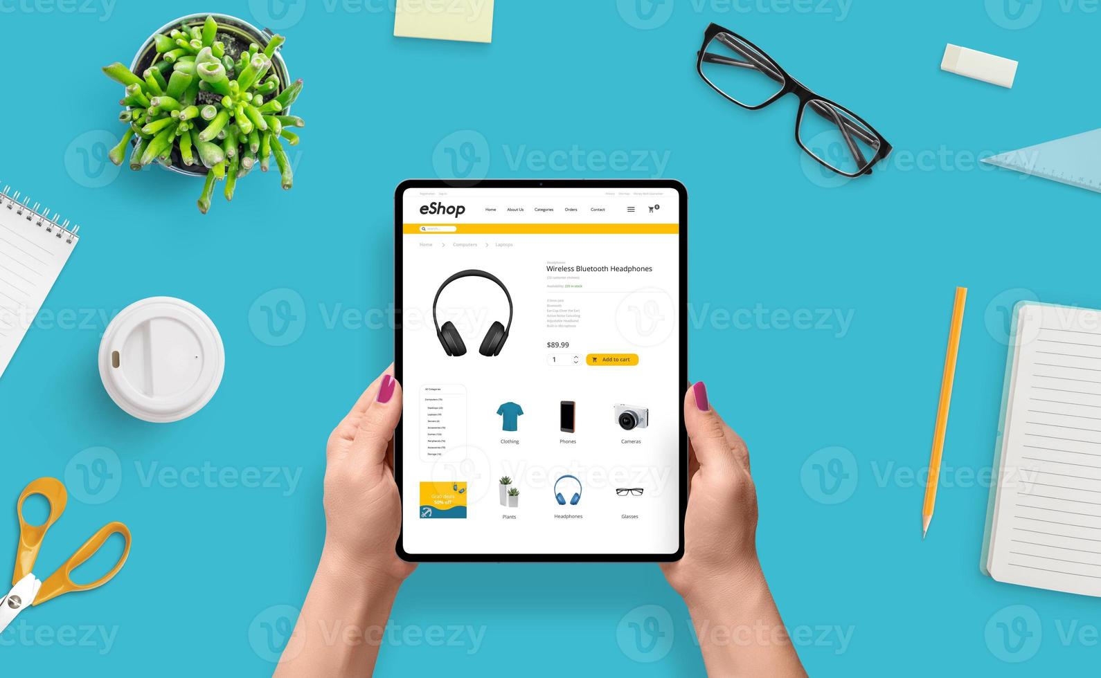 Online shoping with tablet concept. Girl use e-commerce web site for buy headphones. Top view, flat lay photo