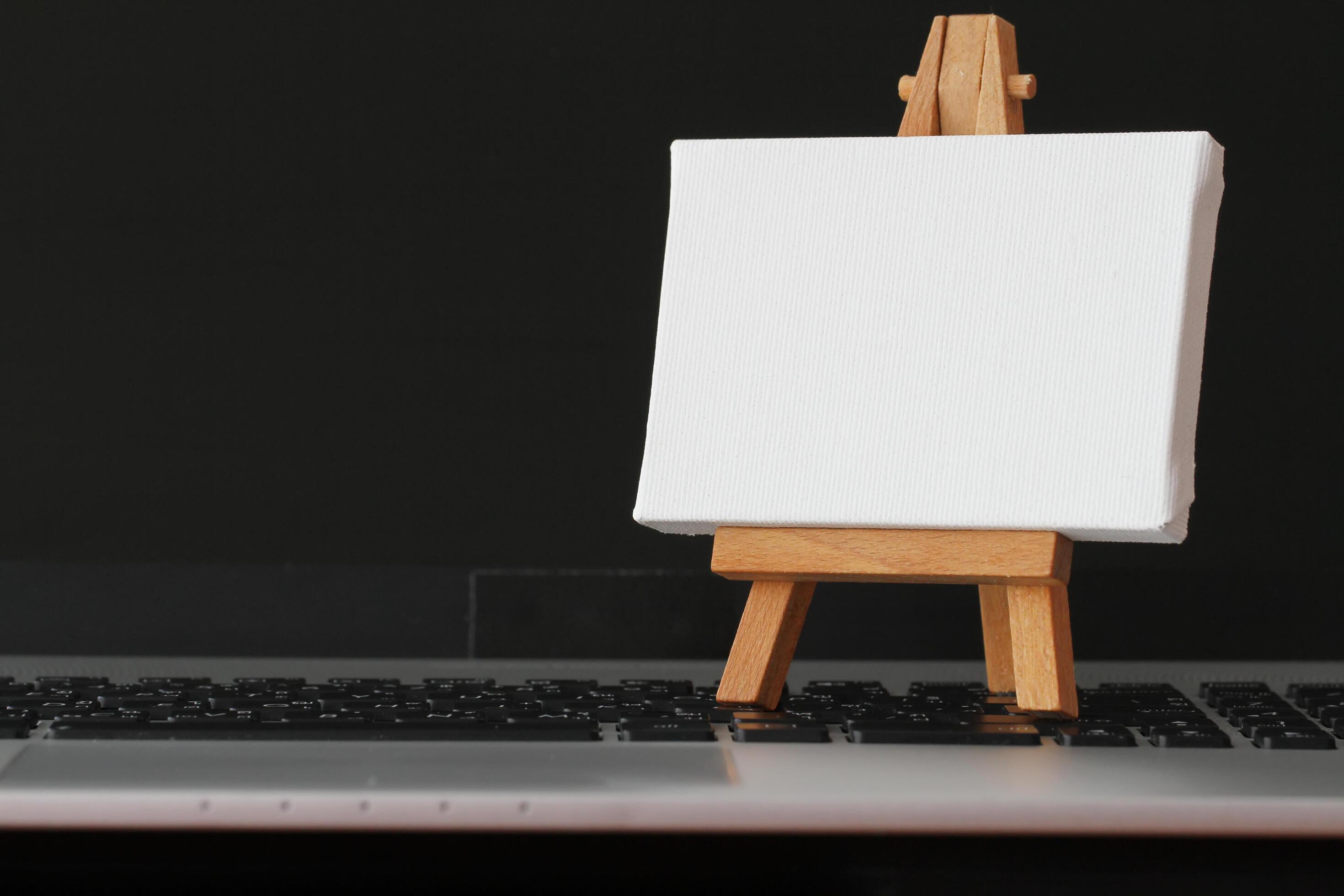 blank canvas and wooden easel on laptop computer as concept 5231814