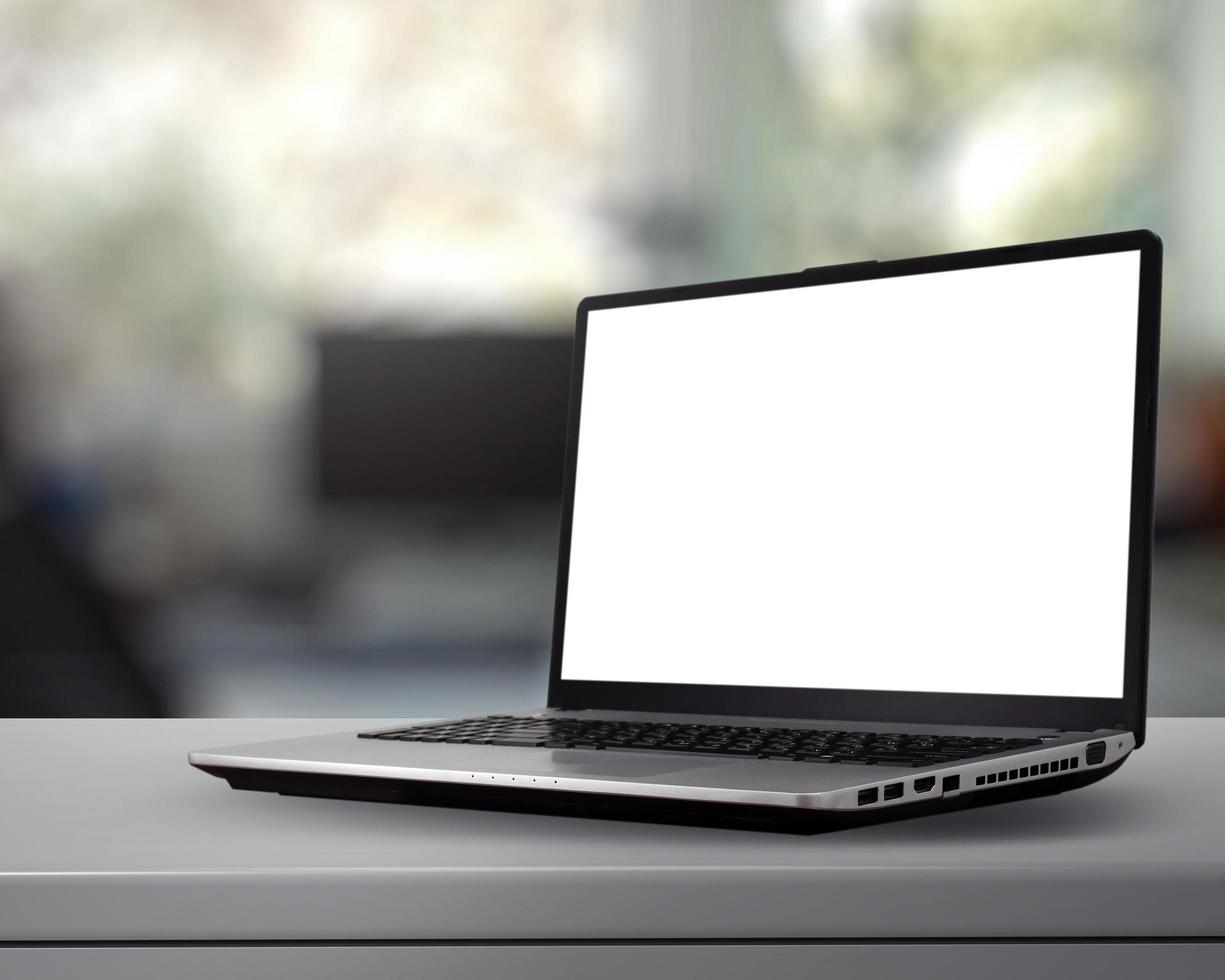 Portátil con pantalla en blanco sobre un escritorio blanco con fondo borroso como concepto foto