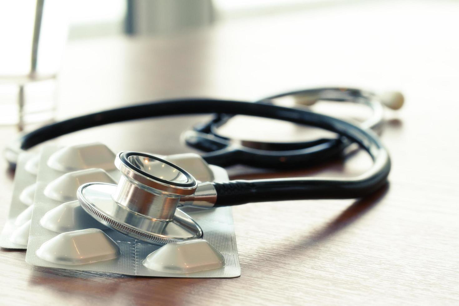 Studio macro of a stethoscope and digital tablet with shallow DOF evenly matched abstract on wood table background copy space photo