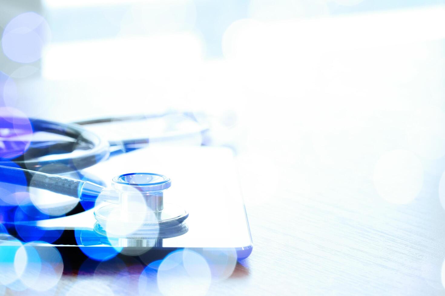 Studio macro of a stethoscope and digital tablet with shallow DOF evenly matched abstract on wood table background copy space photo