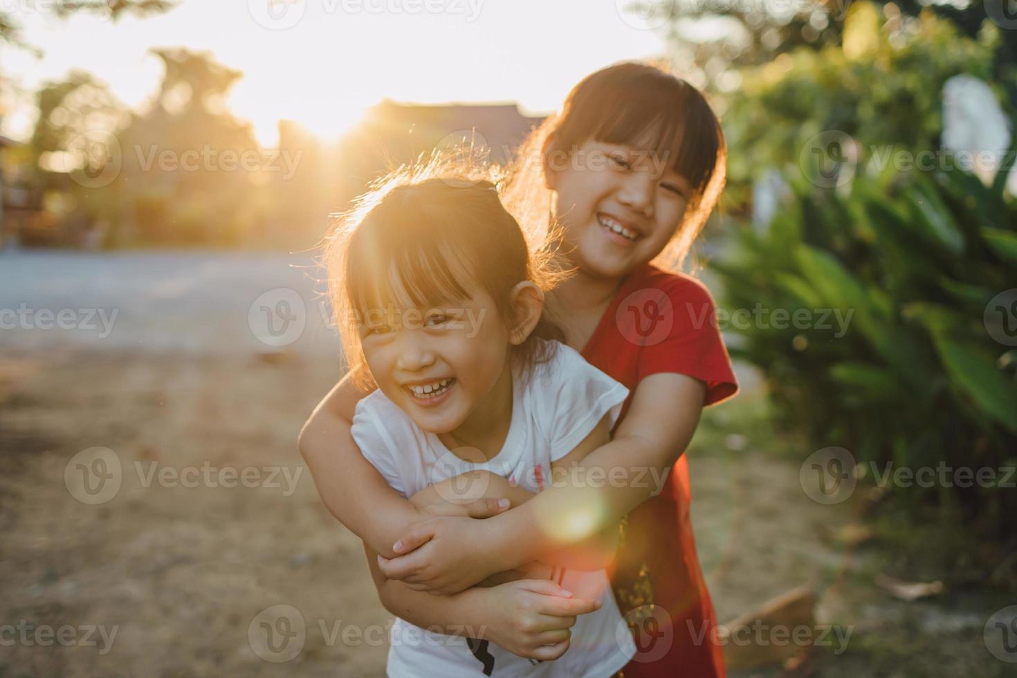 retrato de personas de una expresión facial emocional de sonreír y reír de niños hermanos asiáticos de 6 años. familia sana y felicidad niños jugando juntos concepto foto