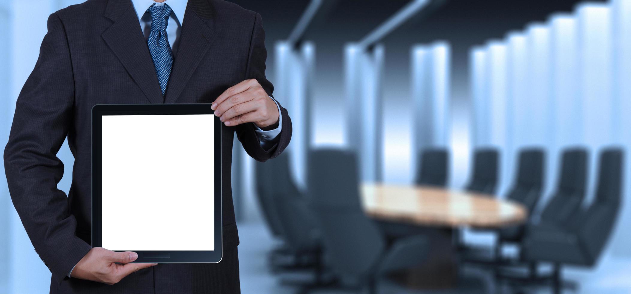 el éxito del hombre de negocios trabajando con una tableta en blanco en su sala de juntas foto